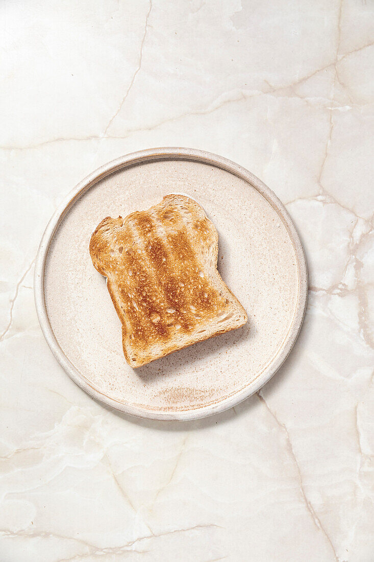 Toast auf Keramikteller vor einem Marmorhintergrund