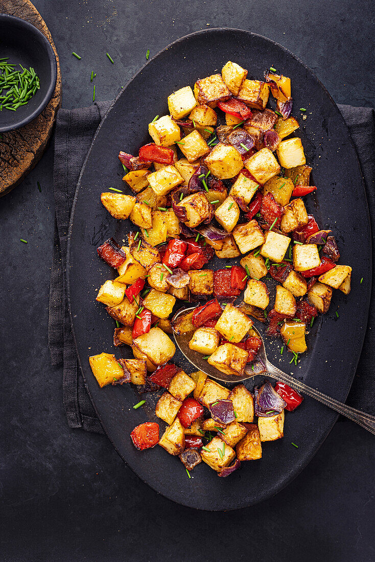 Roasted potatoes, peppers and onions on an oval tray