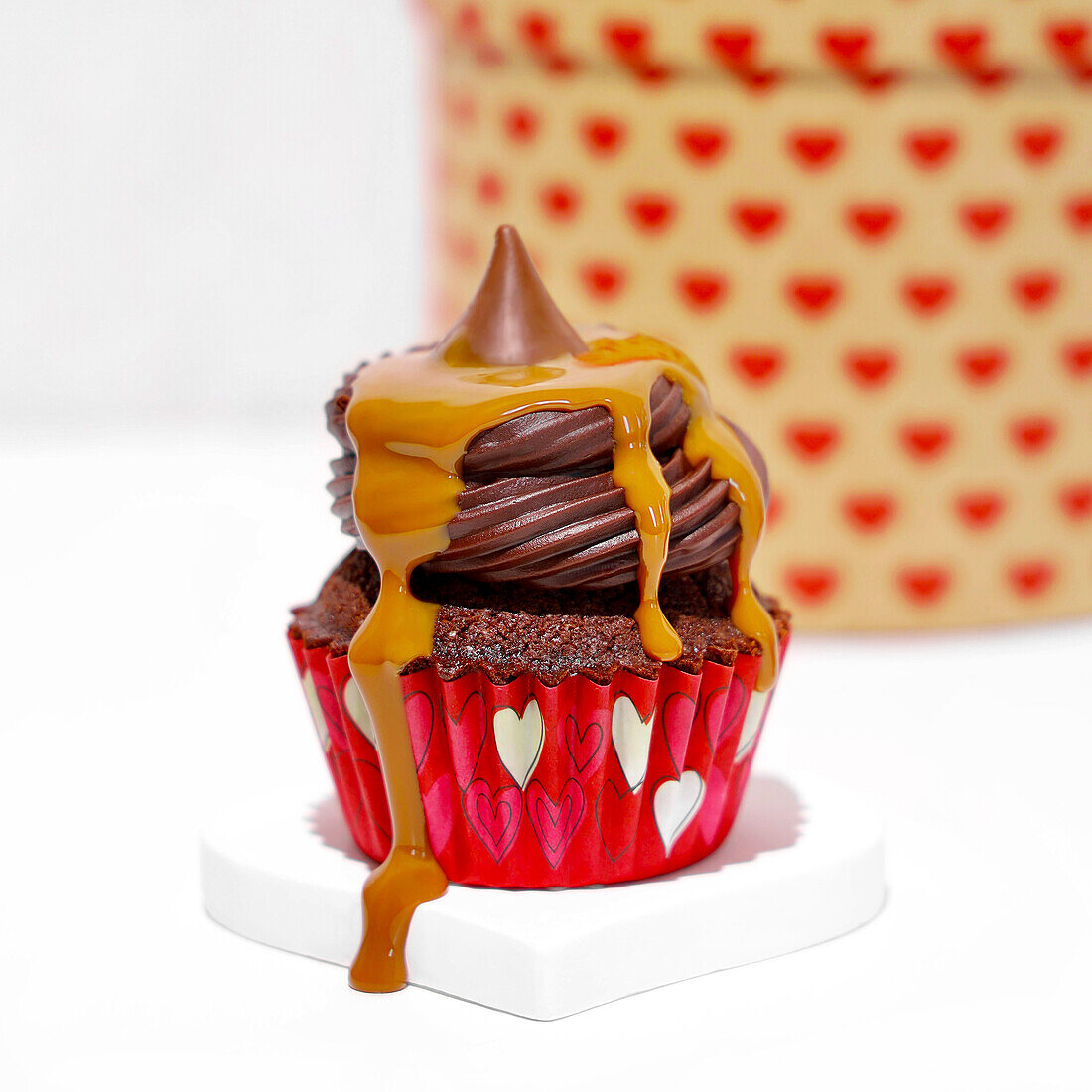 Chocolate cupcake with toffee sauce on a white background