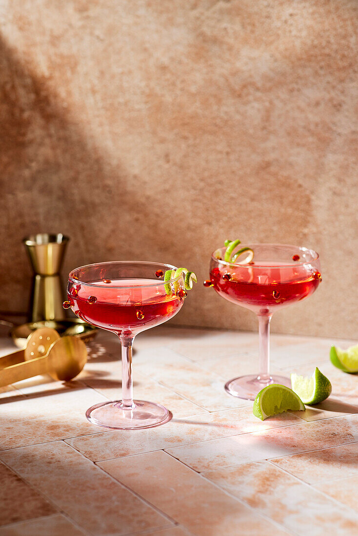 A cosmopolitan cocktail in a traditional glass, on a pink bar