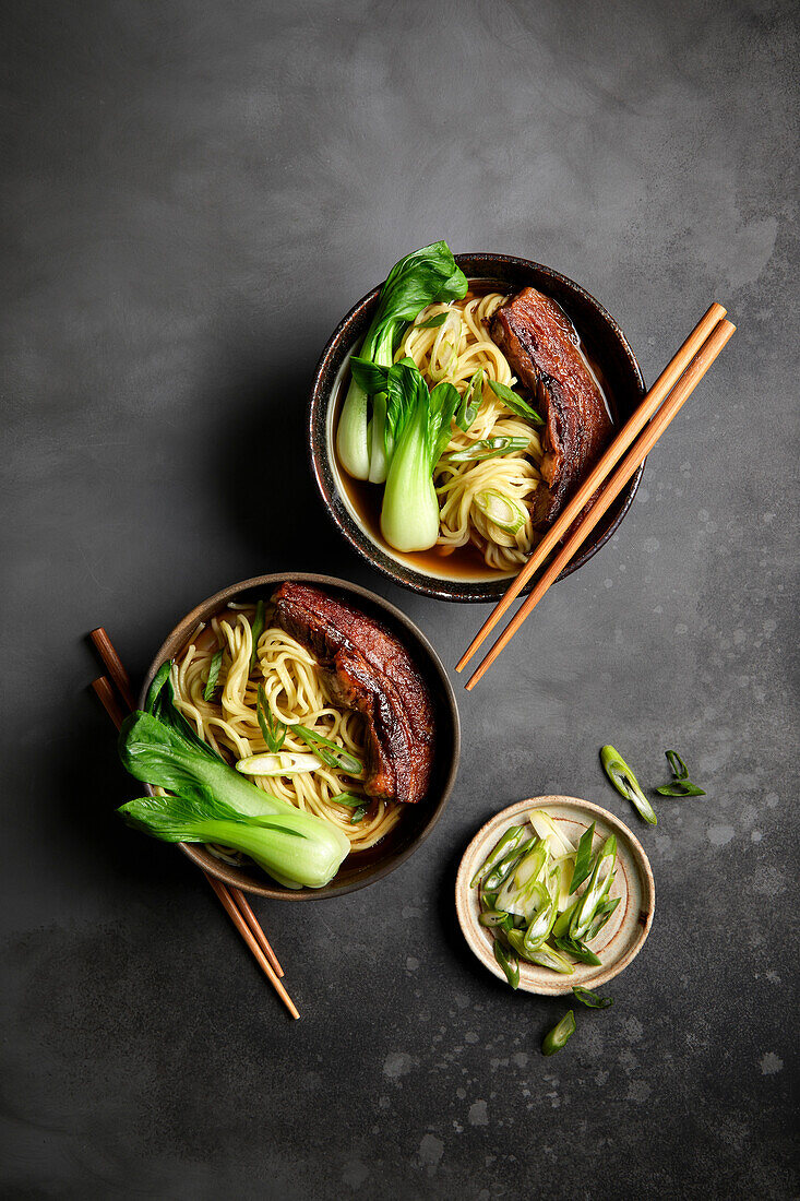 Ramen, pork belly and bok choy with black background
