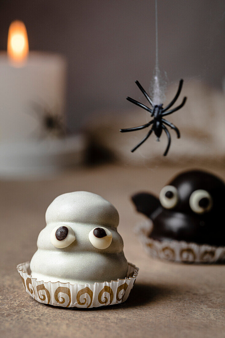 Geisterbonbon auf dem Tisch für Halloween; mit Keksboden, Dulce de Leche-Füllung und weißer Schokolade überzogen