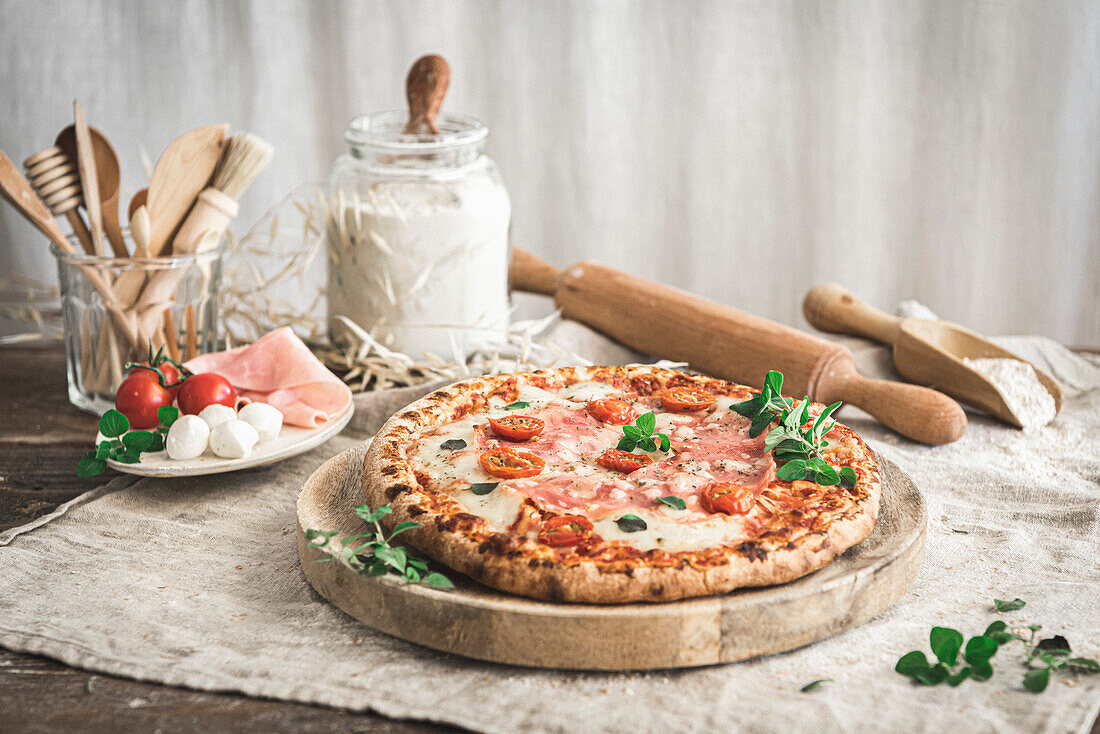 Schinken-Mozzarella-Pizza auf einem Schneidebrett