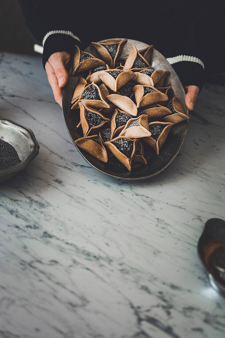 Hamantaschen-Kekse auf einem Marmortisch mit Kopierfläche