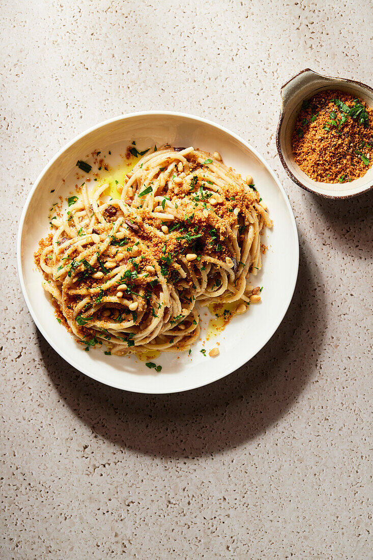 Spaghetti with olives, pine nuts and toasted breadcrumbs