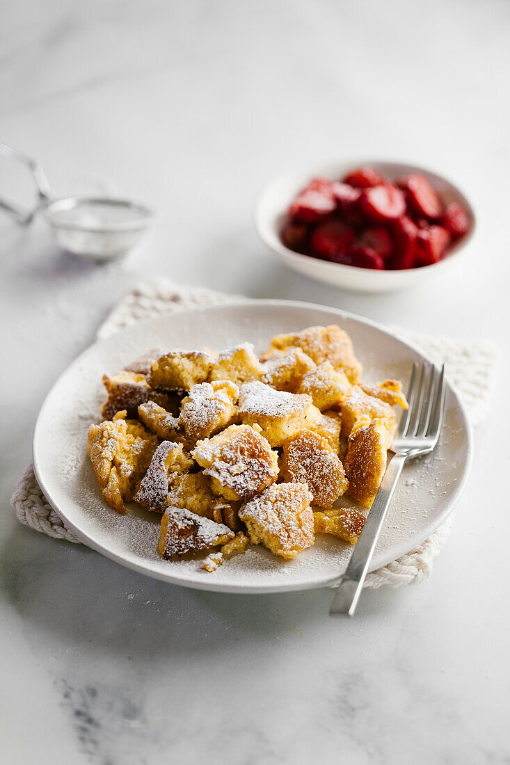 A plate of torn French toast pancakes and strawberry compote