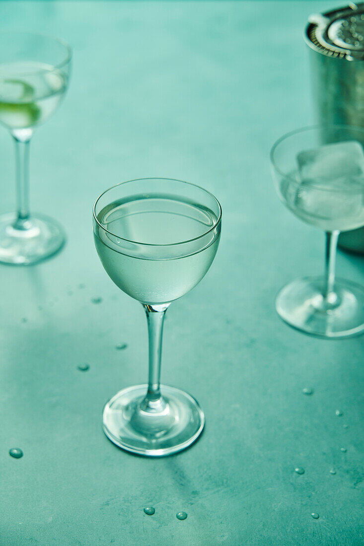 Dry martini with lime on a sage green background