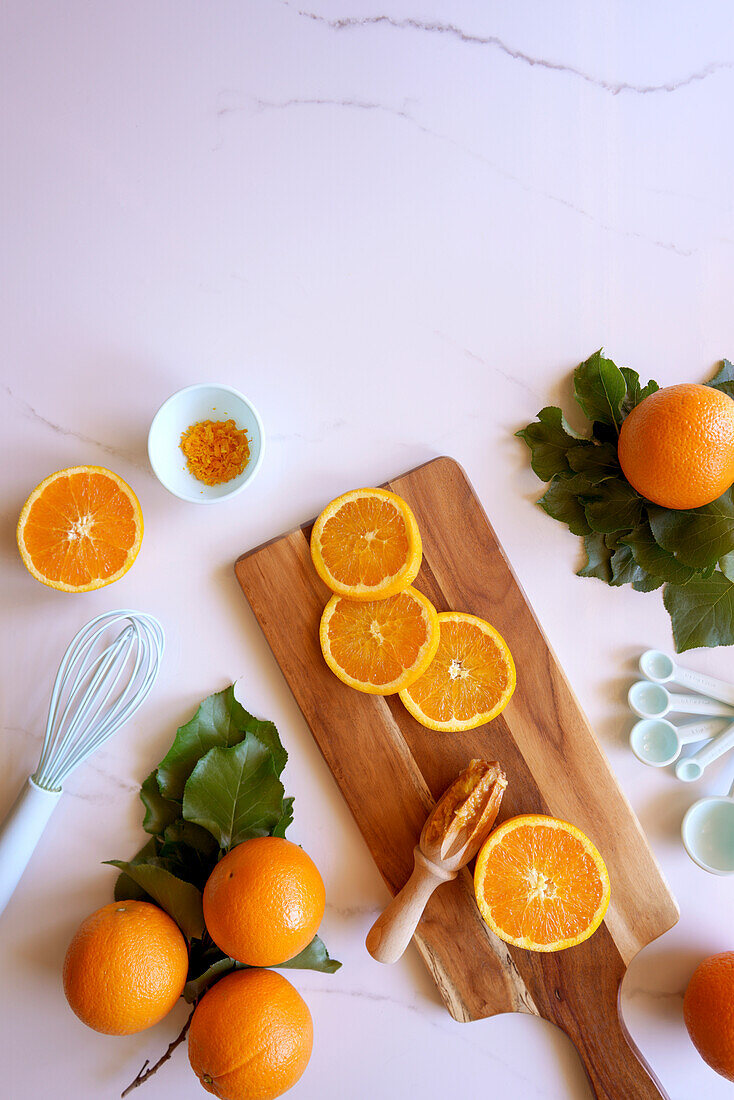 Kochen und Backen mit Orangen Lebensmittelzubereitung auf weißem Marmor Hintergrund. Flatlay von oben nach unten mit negativem Kopierraum