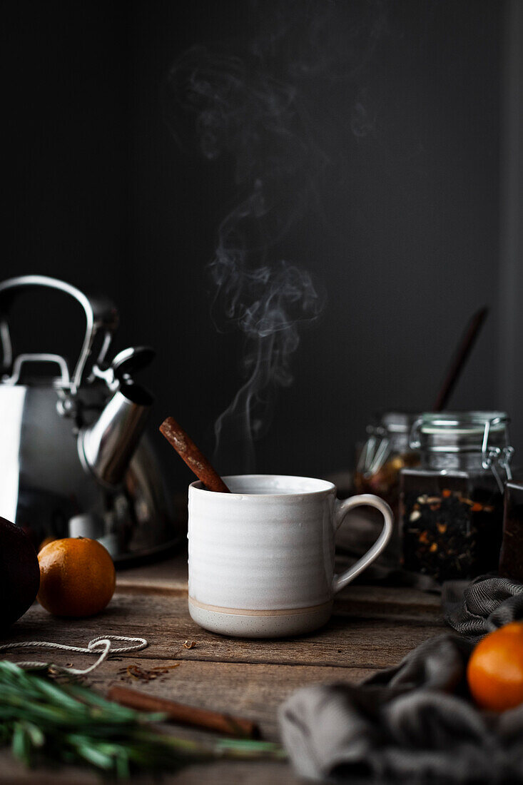 A cosy cup of tea with cinnamon, oranges and greens