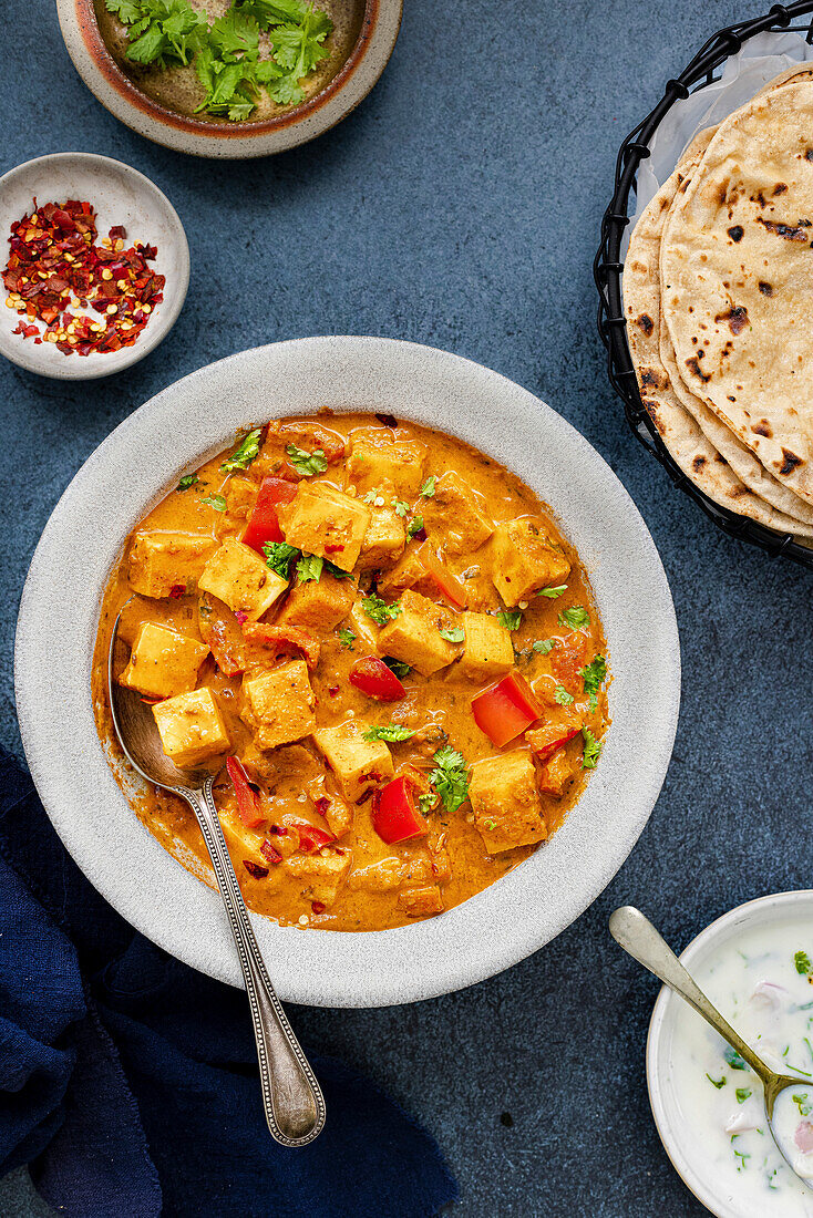 Bowl with paneer curry and side dishes