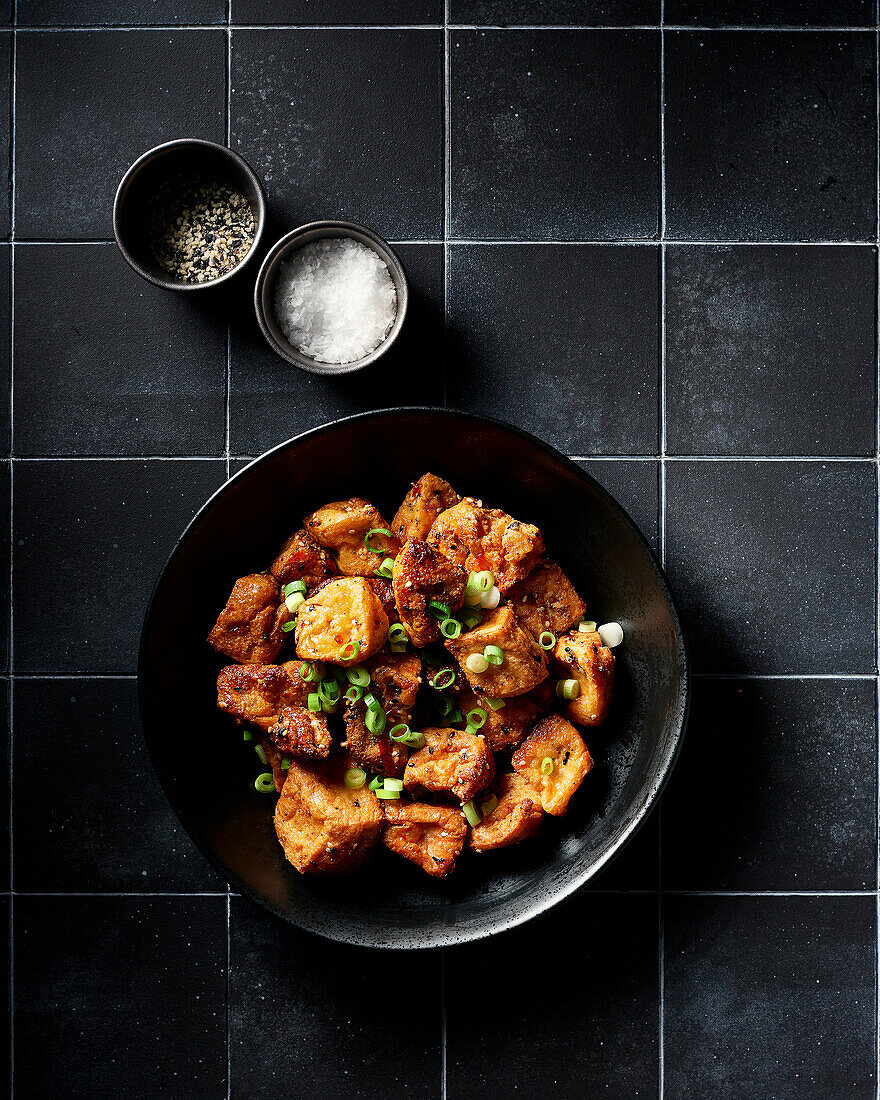 Schüssel mit gebratenem Tofu und grünen Zwiebeln