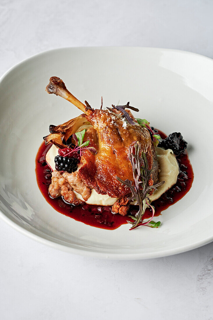 Roasted, confit duck leg, parsnip puree, chipolata of spiced pork and fennel seeds, roasted fennel bulb, duck jus, boysenberries