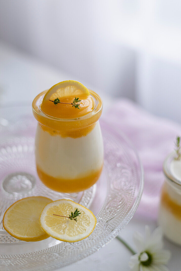 Lemon curd and Greek yoghurt with thyme in glass jars. Gentle romantic scene