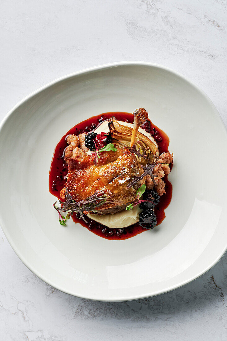 Roasted, confit duck leg, parsnip puree, chipolata of spiced pork and fennel seeds, roasted fennel bulb, duck jus, boysenberries