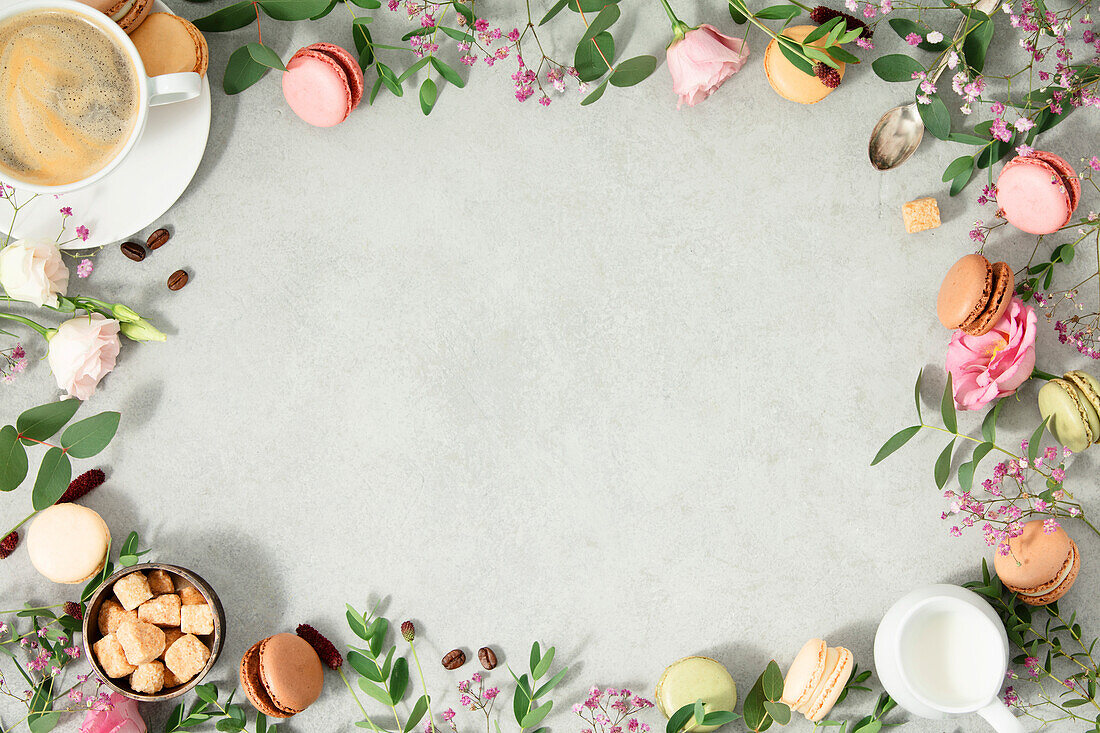 Frame made of Spring flowers,Different types of macaroons and coffee flat lay