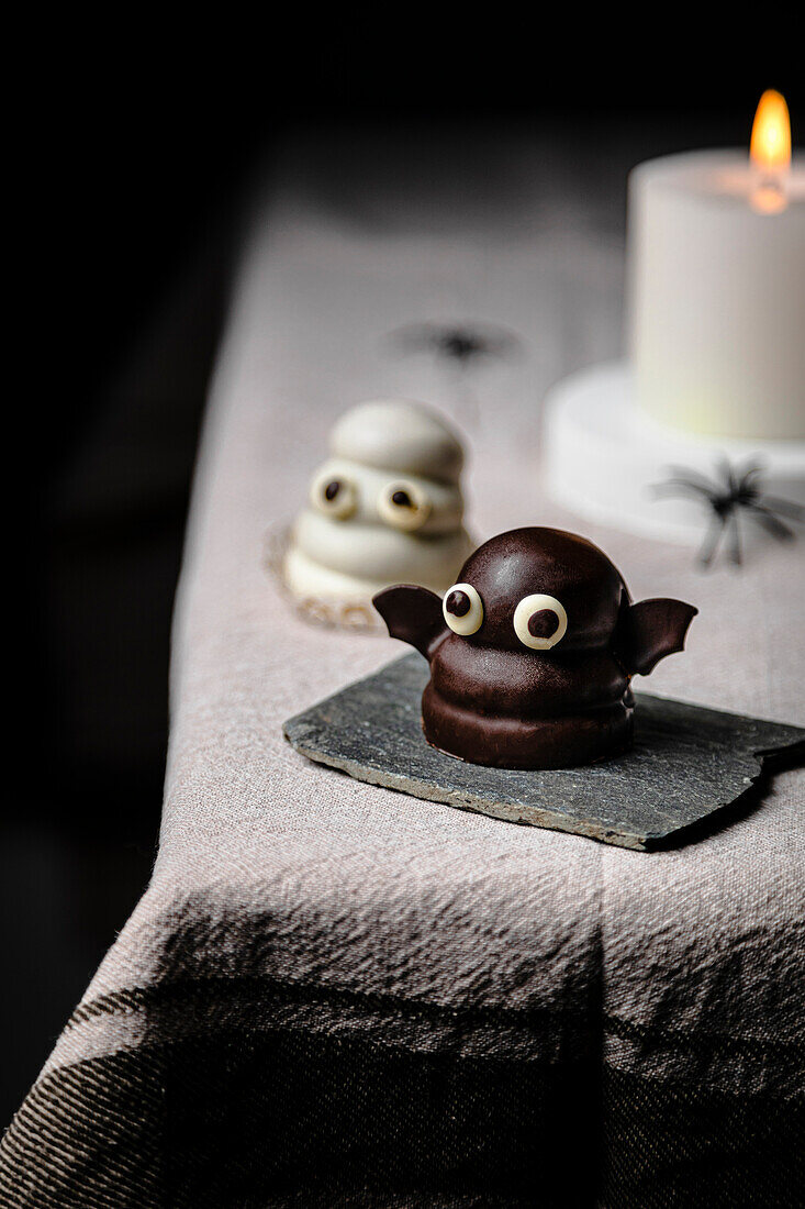 Bat candy over the table for Halloween; made with biscuits, dulce de leche and dark chocolate coating.