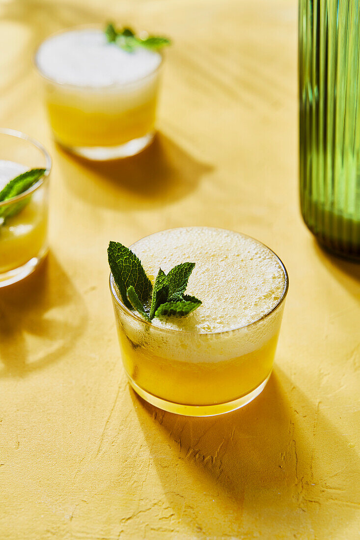 Pineapple Mint G&Ts mit Ausgießer auf gelbem Hintergrund mit Schatten