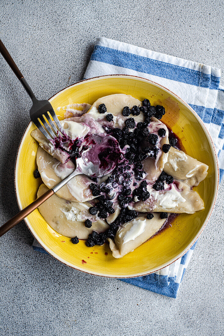 Leckere traditionelle ukrainische Teigtaschen mit Heidelbeeren und saurer Sahne