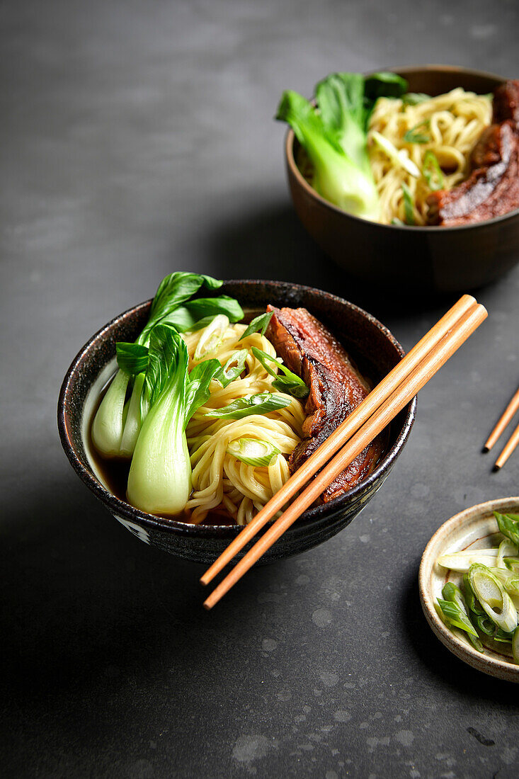 Ramen, Schweinebauch und Bok Choy mit schwarzem Hintergrund