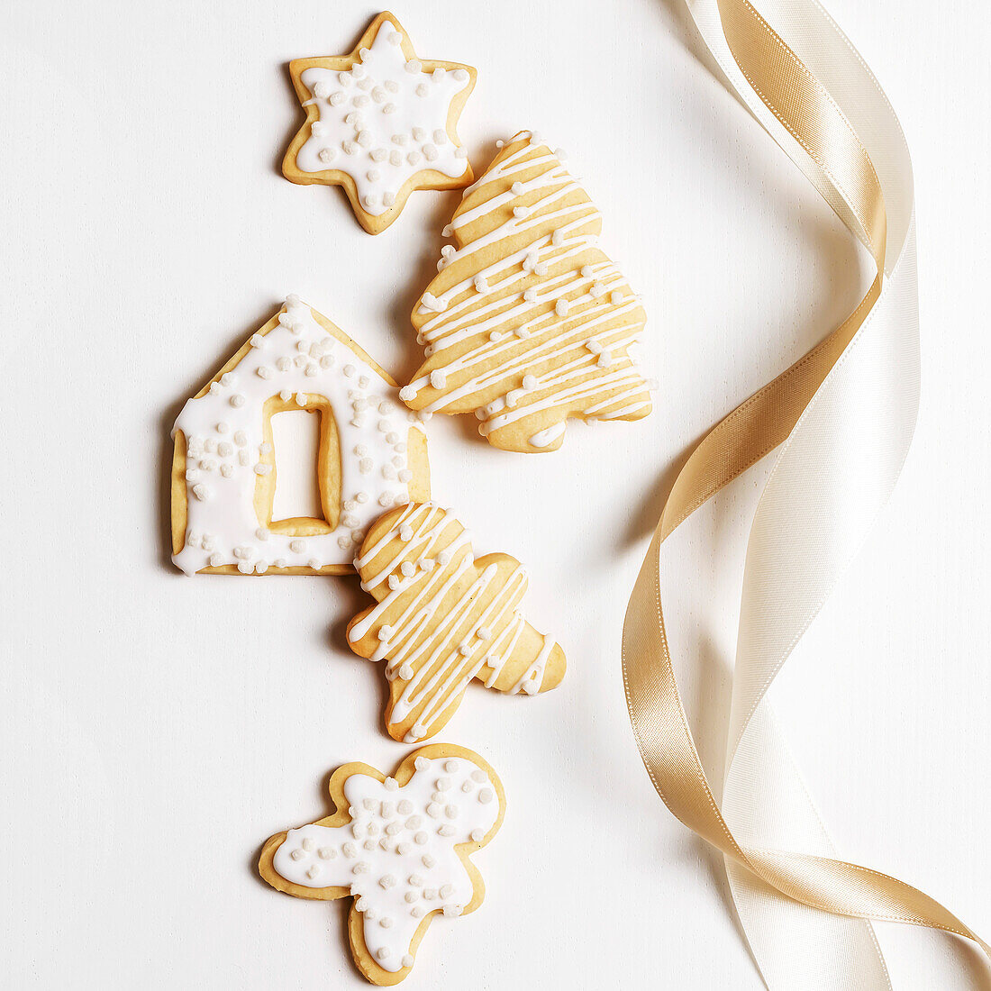 Weihnachtsplätzchen mit Zuckerguss auf weißem Hintergrund mit Schleife