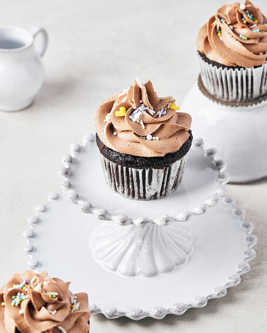 Vegane Schokoladen-Feigen-Cupcakes mit veganem Schokoladen-Irish-Cream-Frosting auf hellem Hintergrund