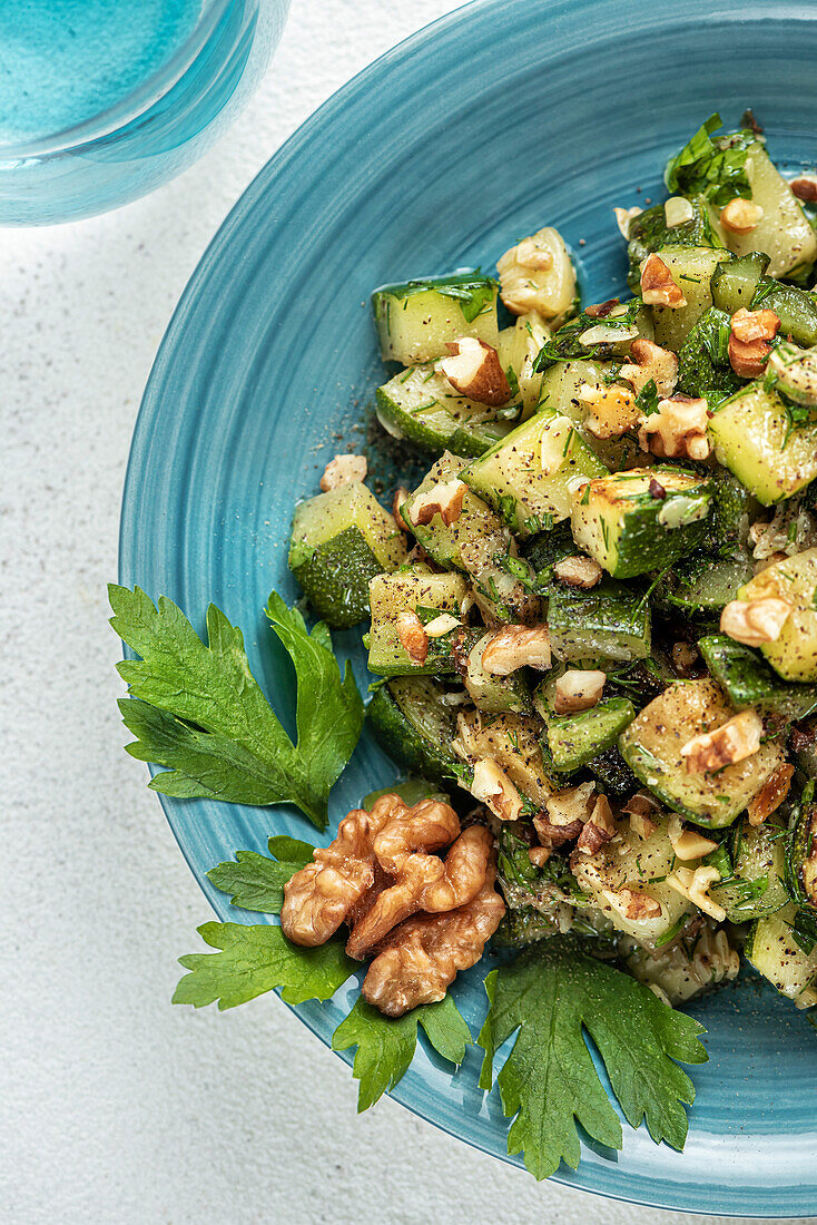 Gebratene Zucchini und Walnusssalat, gewürzt mit Petersilie und Dill. Nahaufnahme