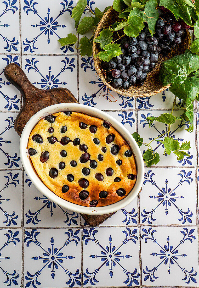 Red grape clafoutis, French cuisine. on a ceramic tile table with blue pattern