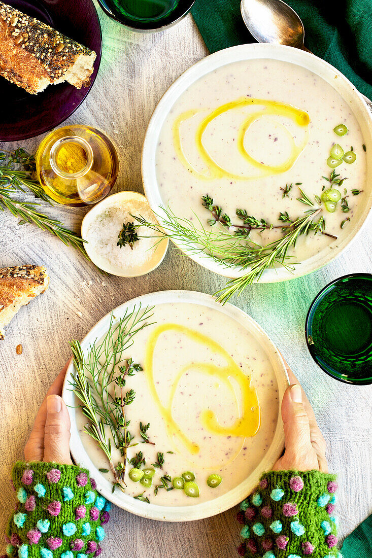 Lila Kartoffel-Fenchel-Bisque auf einem weißen Tisch