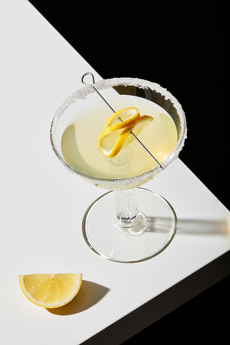 Lemon cocktail on a white table and black background