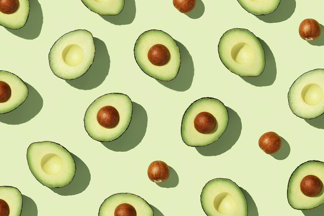 Avocado on a green background Pattern top view flat lay. Summer colour. Minimal concept