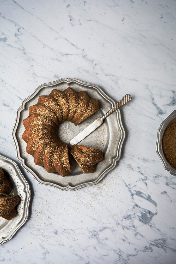 Banana Cake bundt vegan cake on a silver platter tray, with a marble background