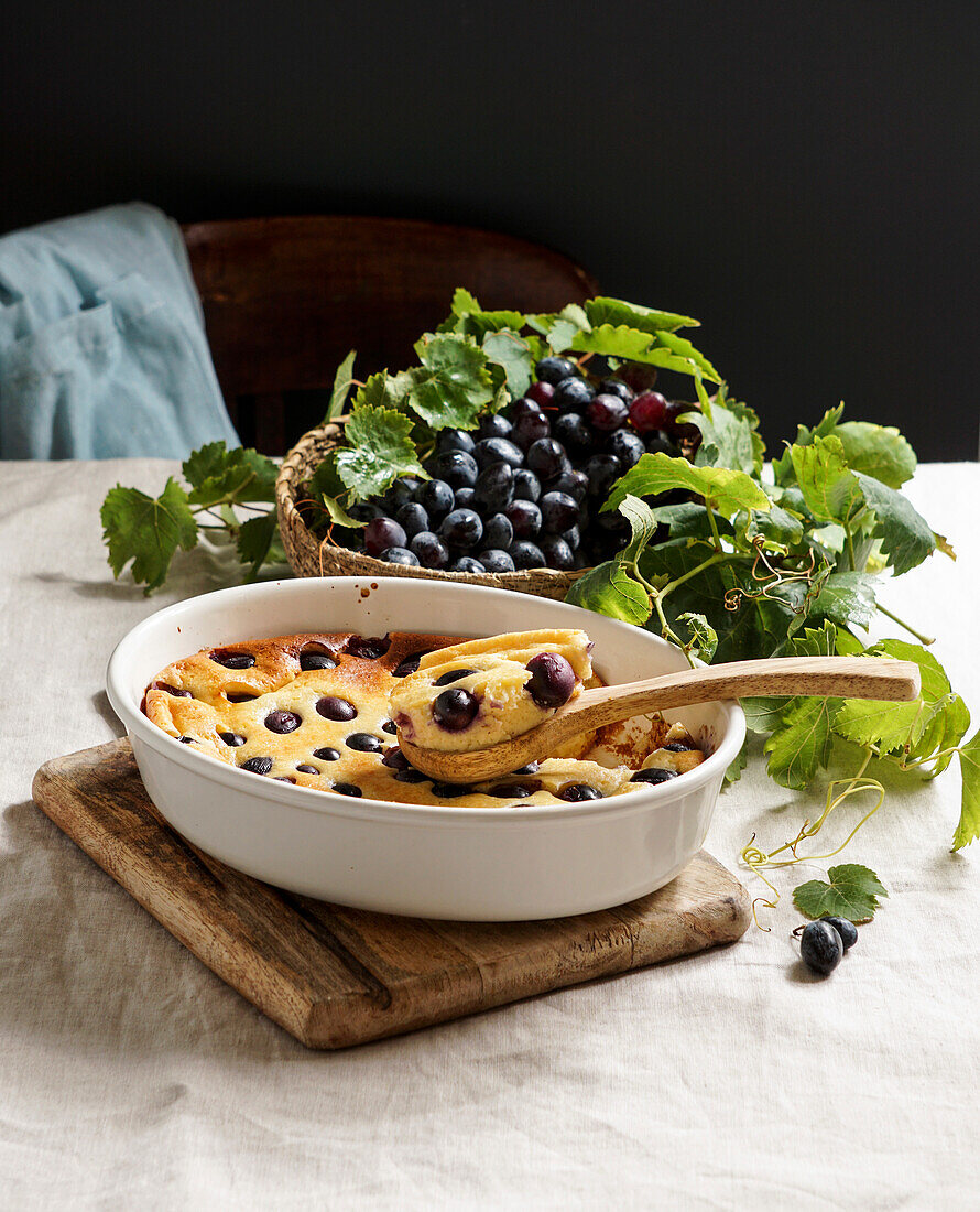 Rote Weintrauben-Clafoutis, französische Küche. auf einem Tisch aus Keramikfliesen mit blauem Muster
