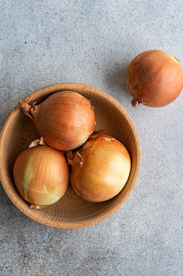 From above of raw organic onion heads on the kitchen table before cooking