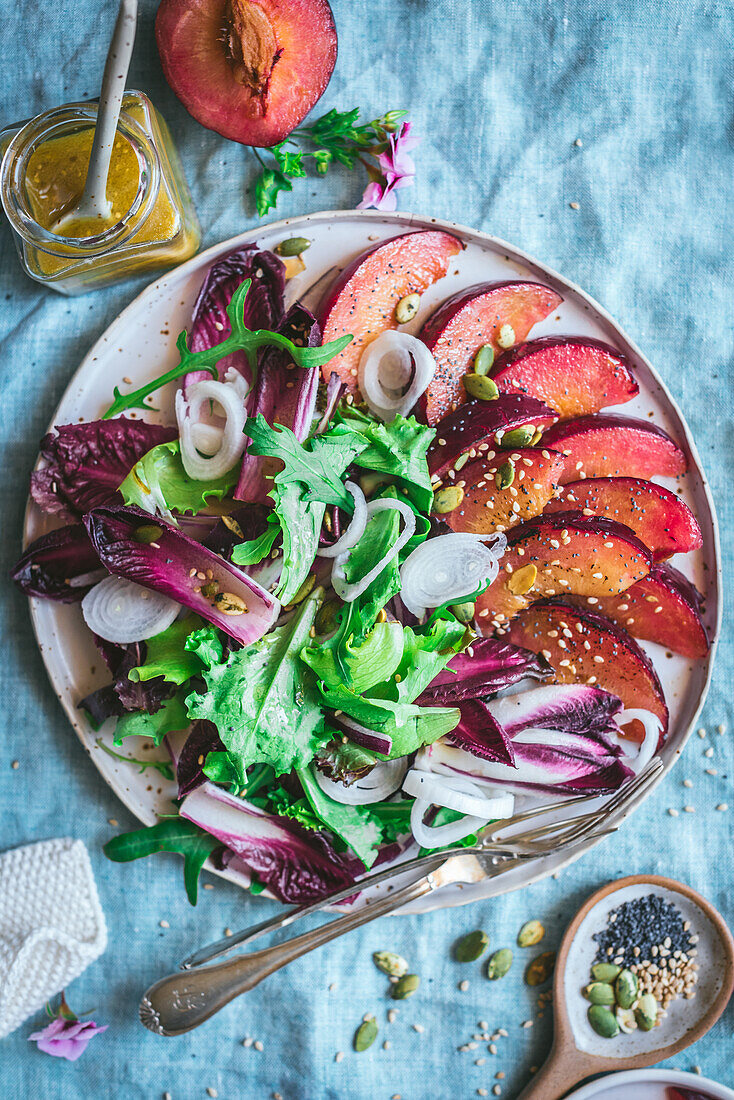 Top view of delicious healthy grilled Plum and Endive salad with assorted vegetables and spices placed on table