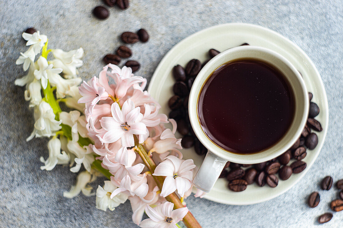 Cup of black coffee served on concrete table in the sunny morning