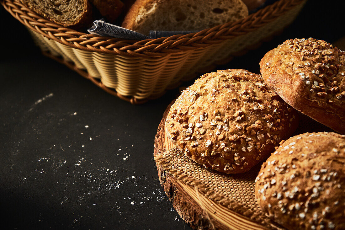 Delicious freshly baked bread with crispy crust sprinkled with mix of seeds and placed on wooden cutting board