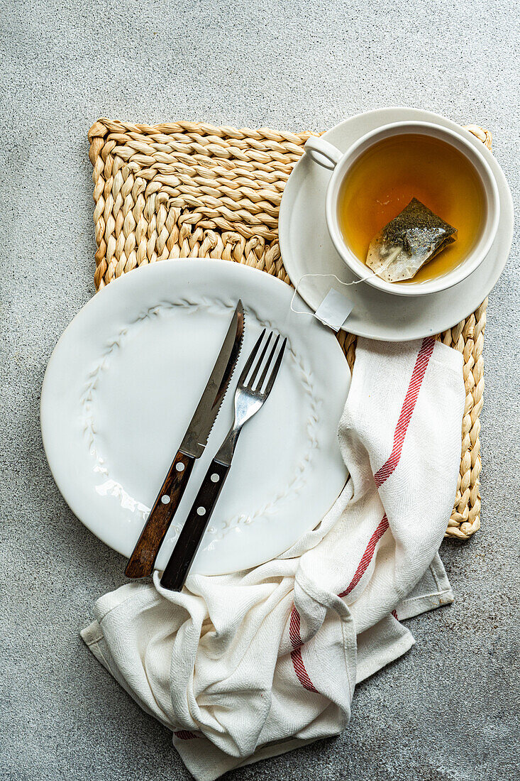 Von oben weißer stilvoller Becher mit heißem aromatischem Grüntee mit Etikett auf einem Betontisch