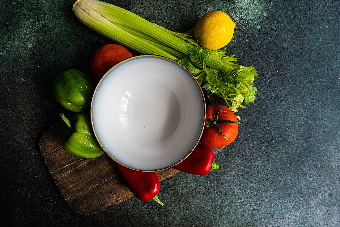 Draufsicht auf einen gesunden Gemüsesalat mit Zutaten auf einem Betontisch, bereit zum Kochen