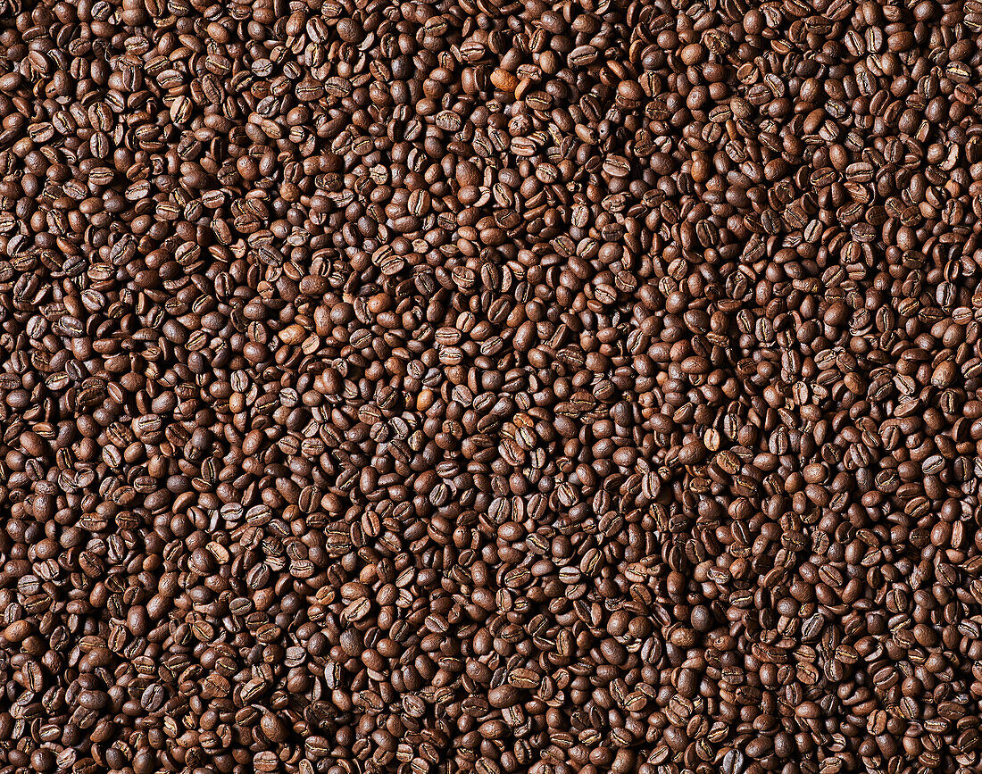 Top view background of aromatic brown coffee beans scattered on surface