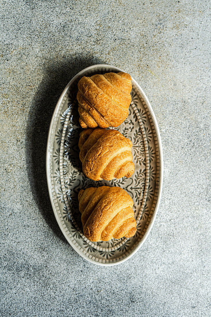 Draufsicht auf frisch gebackene Croissants auf einem Betonhintergrund