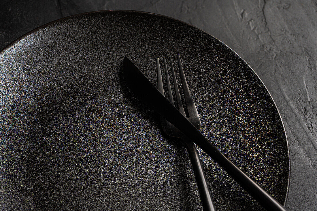 Minimalistic table setting with tableware and cutlery on concrete background