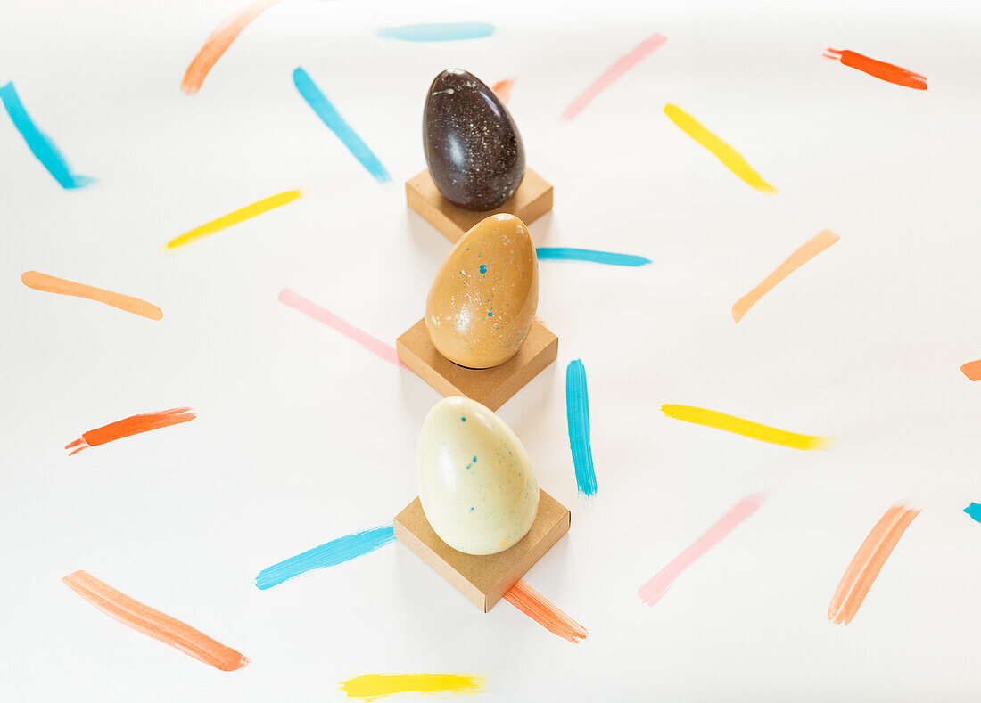 A creative arrangement of decorated Easter eggs on a white background with colorful strokes