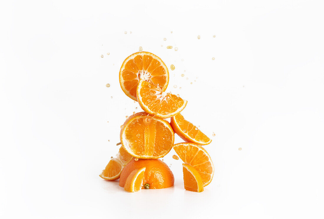 Fresh juicy sliced oranges with droplets and a white background