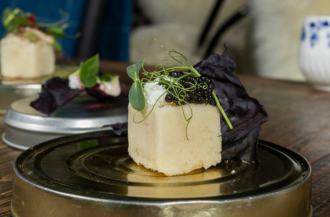 Exquisite Michelin-Stern-Fusionsküche mit einem delikaten Gericht mit Kaviar und frischen Kräutern, das das Engagement von Zermatt für lokale und saisonale Zutaten unterstreicht