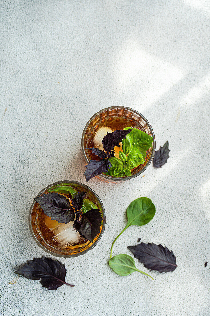 Glass of cocktail with tonic and fresh basil herb leaves