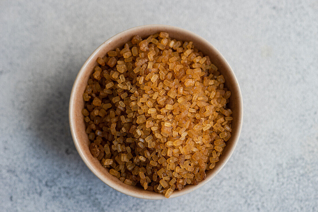 Organic brown textured sugar crystals in the bowl
