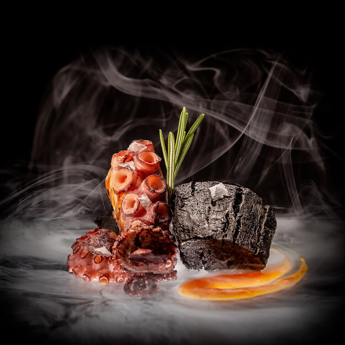 Appetizing octopus tentacles with green rosemary sprig and sauce placed near piece of wood on black surface in smoke