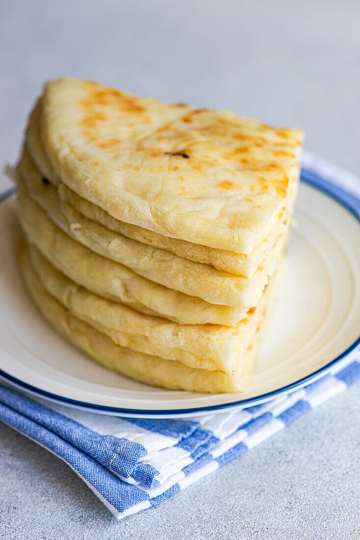 Fokus Traditionelles georgisches Gericht "Imeruli khachapuri" (Brotkuchen) mit Sulguni-Käse auf dem Teller