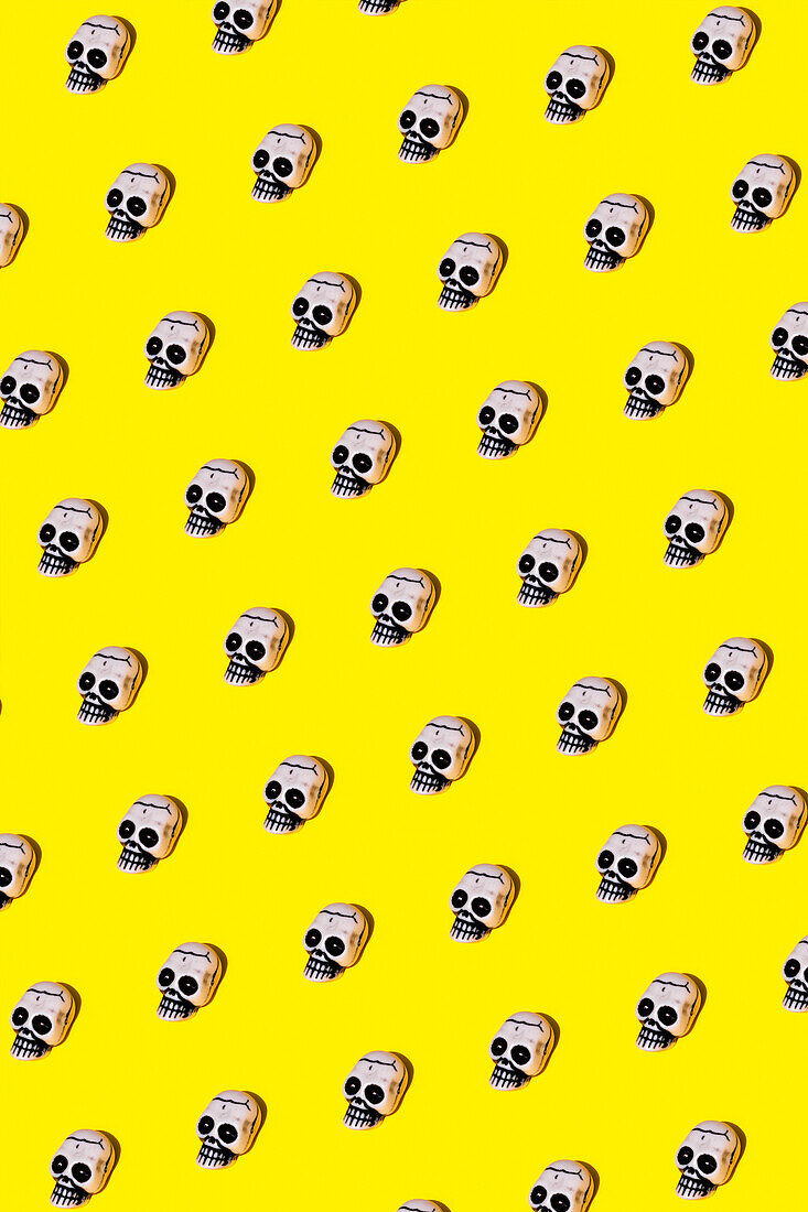 Vector illustration of small human skulls with creepy paint placed in symmetrical rhomb on vibrant yellow background