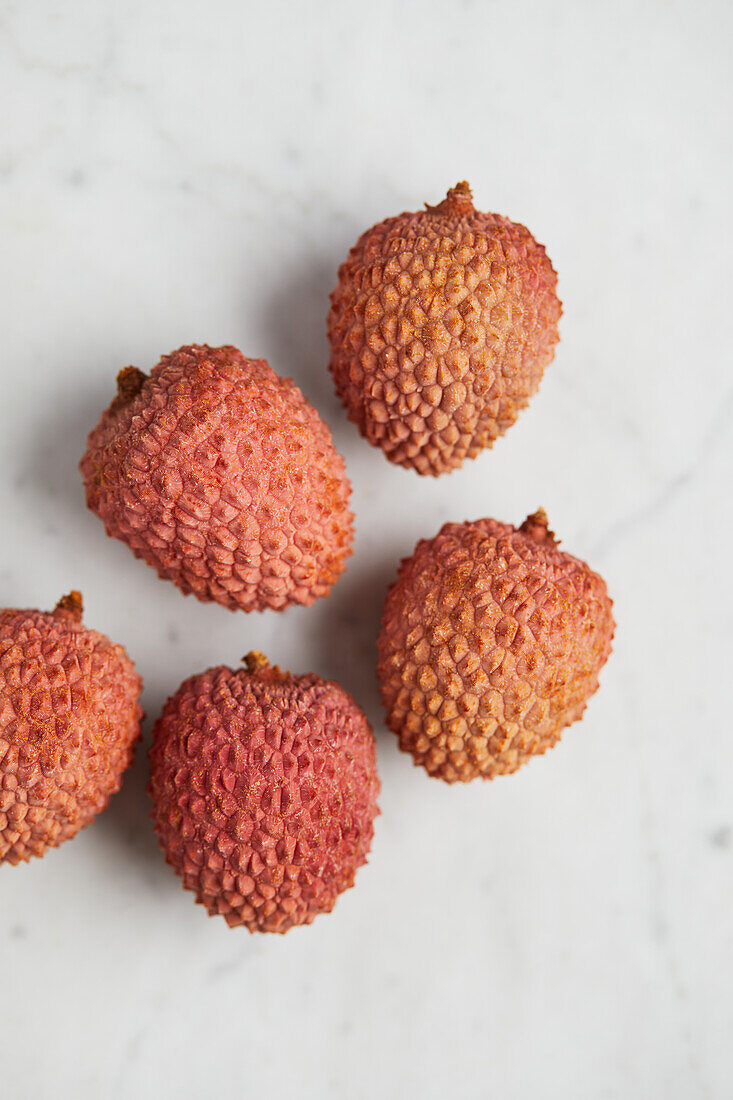 Top view of delicious fresh and ripe lychee fruits on smooth surface with marble background